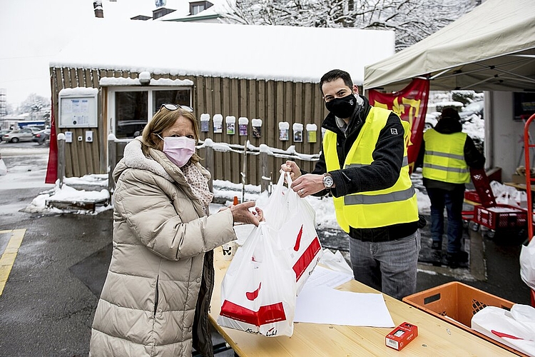 Vreni Stalder hat zu Hause einen langen Tisch in den Zunftfarben Rot und Gelb mit Rosen geschmückt. Elias Wagner übergibt ihr die bestellte Pastete.