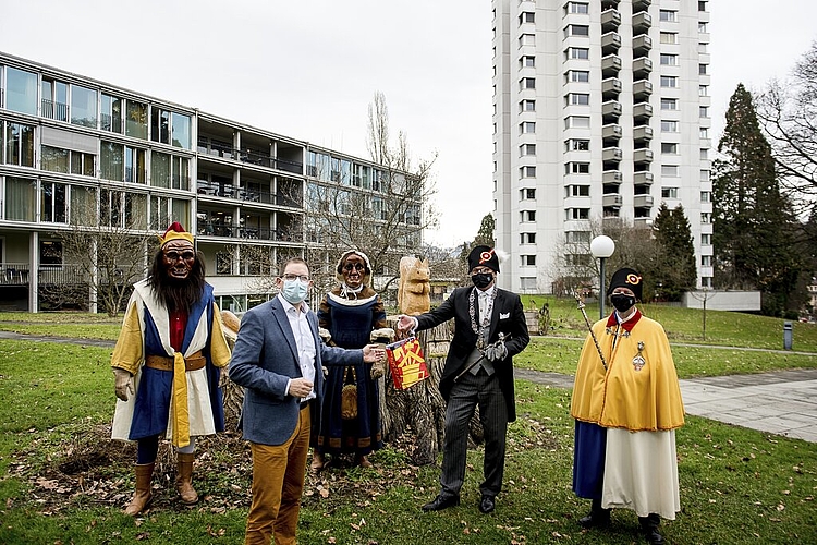 Dani Medici, Zunftmeister Zunft zu Safran, überreicht mit Bruder Fritschi (l.), Fritschene und Weibel Richi Hess (r.) Joel Früh, Betriebsleiter Betagtenzentrum Viva Luzern Eichhof, ein Zunftsäckli.
