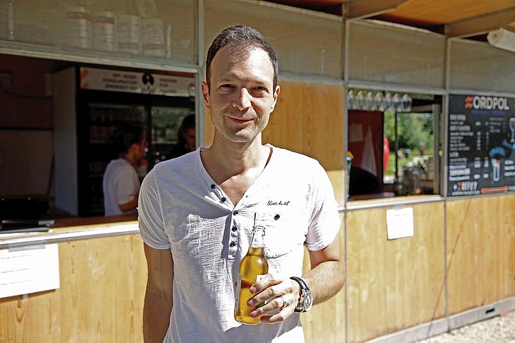 Daniel Fischer geniesst das schöne und warme Wetter am Reusszopf mit einem kühlen Getränk.
