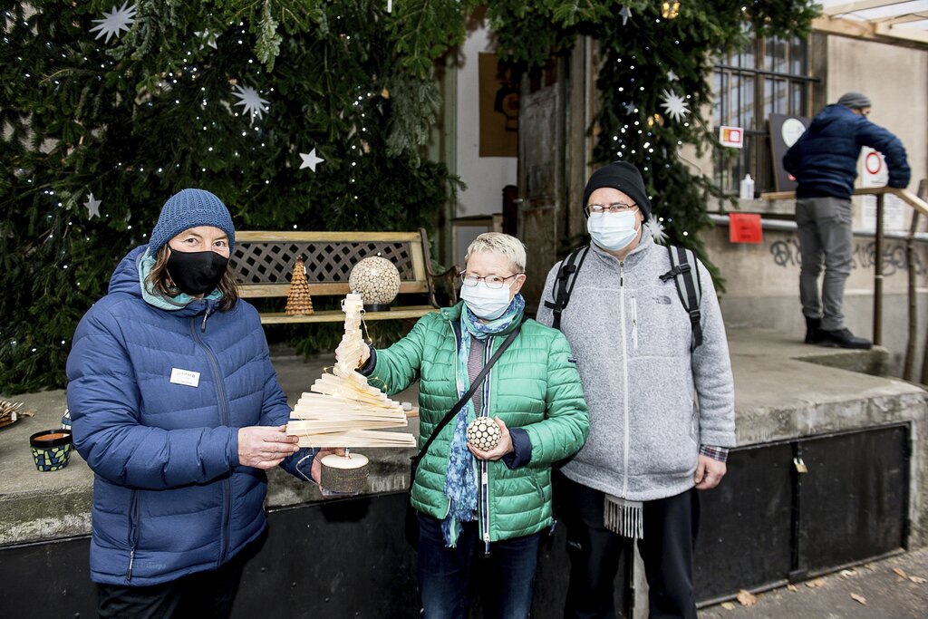 Brigit und Hannes Ernst lassen sich von Pia Baumeler (l.) vom Verein Jobdach den handgemachten Weihnachtsbaum zeigen.
